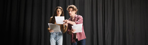 A man and a woman captivate the stage during theater rehearsals.