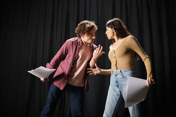 Мужчина и женщина позируют на черном фоне.