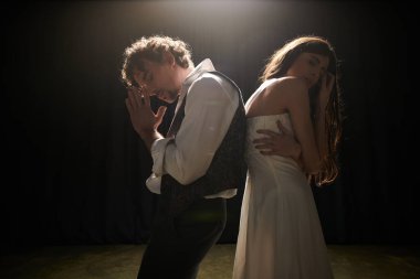 Bir adam ve bir kadın loş bir odada birlikte bir tiyatro gösterisi için prova yapıyorlar..