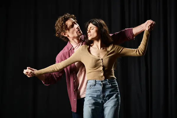 stock image A man and a woman gracefully dance together in a theater rehearsal.