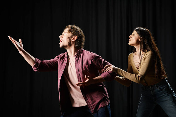 Красивый мужчина и женщина репетируют на сцене.