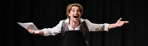 stock image A man in a white shirt performing happily in theater.