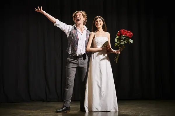 stock image A man and woman elegantly stand on a theater stage during rehearsals.