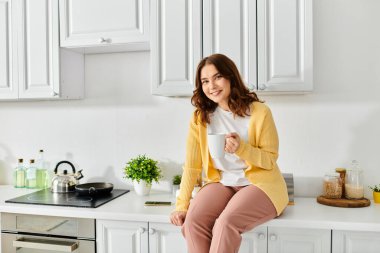 A middle aged woman sitting gracefully on a kitchen counter. clipart