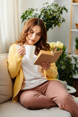 Orta yaşlı bir kadın elinde kahve fincanıyla koltukta dinleniyor..