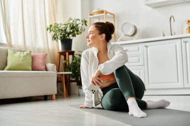 Rahat oturma odasında yoga yapan orta yaşlı bir kadın..