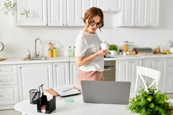 Middle-aged woman holding cup of coffee in cozy kitchen.