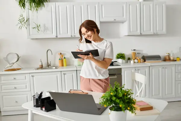 Middle Aged Woman Absorbed Reading Book While Standing Kitchen — Stockfoto