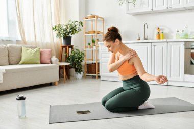 Orta yaşlı bir kadın, rahat bir oturma odasında yoga minderiyle egzersiz yapıyor..