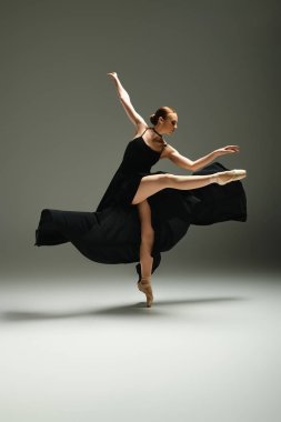 Young, beautiful ballerina dances gracefully in a black dress. clipart