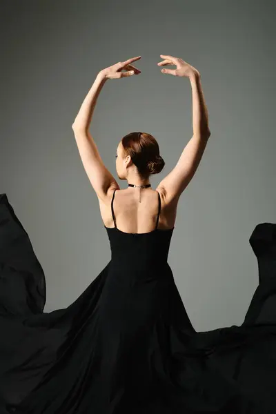 stock image A young, beautiful ballerina dances gracefully in a striking black dress.