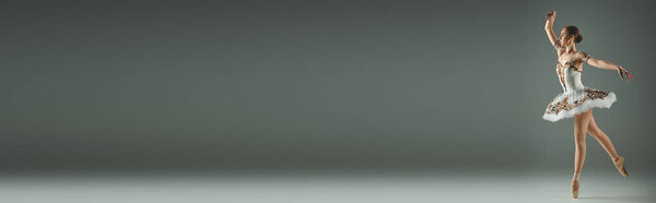 Young, beautiful ballerina in white dress twirling gracefully while dancing.