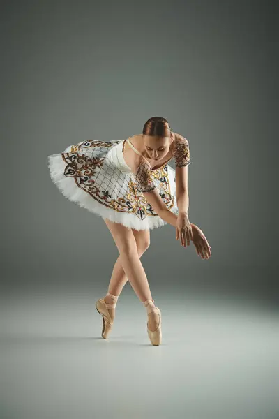 Ung Ballerina Vit Tutu Dansar Graciöst Mot Grå Bakgrund — Stockfoto