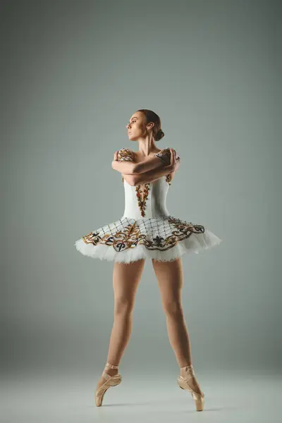 一位年轻美丽的芭蕾舞演员 身穿白色的燕尾服 摆出优雅的姿势 — 图库照片