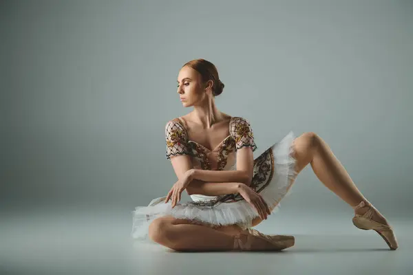 年轻的芭蕾舞演员穿着芭蕾舞服装坐在地板上 散发着优雅优雅的气质 — 图库照片
