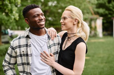 Çok kültürlü bir çift, Afro-Amerikalı bir erkek ve Kafkasyalı bir kadın parkta bir arada durup bir anlık mutluluğu paylaşıyorlar..