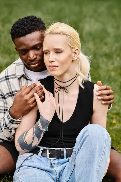 stock image A happy, multicultural couple enjoying a peaceful moment together on the grass.