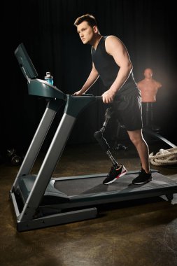 Sakat ve protez bacaklı bir adam loş ışıklı bir spor salonunda koşu bandında koşar, kendini fitness hedeflerine ulaşmak için zorlar..
