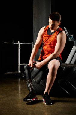 Protez bacaklı engelli bir adam spor salonundaki sandalyeyi fetheder. Egzersiz yaparken güç ve kararlılık gösterir..