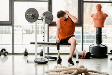 Protez bacaklı bir adam spor salonundaki bankta otururken huzuru bulur. Gücünü ve direncini yansıtır..