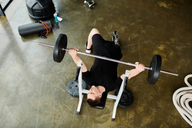 A disabled man with a prosthetic leg lies on the ground, lifting a barbell in a determined and focused manner. clipart
