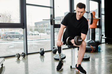Protez bacaklı kararlı bir adam. Spor salonunda halterle egzersiz yapıyor. Güç ve güç kazanmaya çalışıyor..