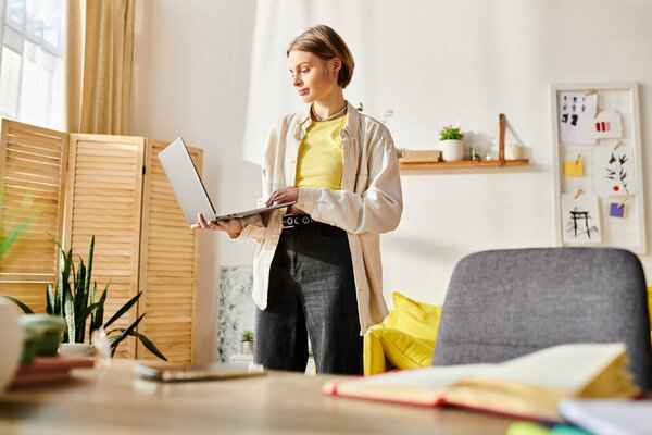A focused teenage girl standing in a room, deeply engaged in e-learning activities on her laptop computer.