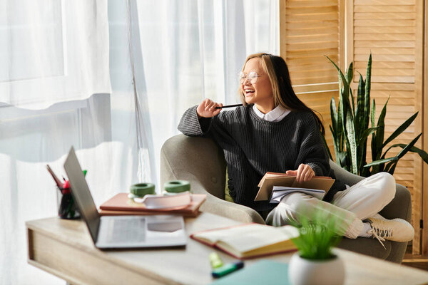 A young Asian woman sits serenely in a chair, engrossed in a book resting on her lap, surrounded by a cozy atmosphere.