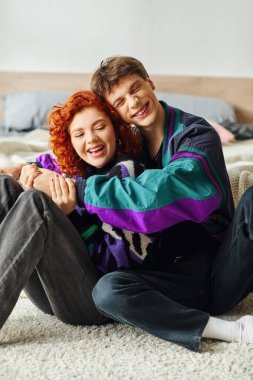 Moda düşkünü, neşeli erkek arkadaş ve kız arkadaş birlikte vakit geçirirken birbirlerine sımsıkı sarılıyorlar.