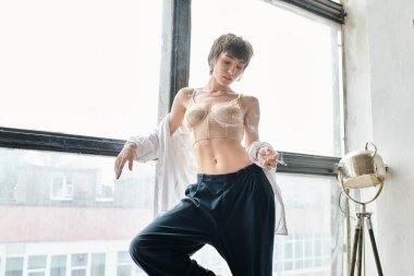 Odada pencerenin önünde düşünceli bir kadın..