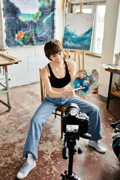 Kvinna Sitter Stol Och Håller Målning Med Omtänksamt Uttryck — Stockfoto