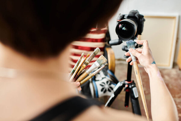 Woman capturing self with camera in natural setting.