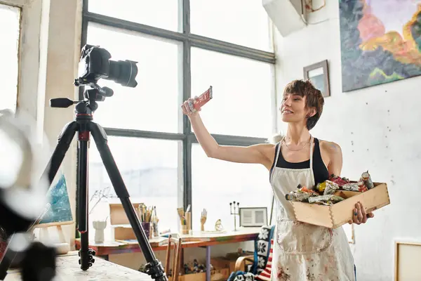 Woman Elegantly Presents Box Paint Front Camera — Stockfoto