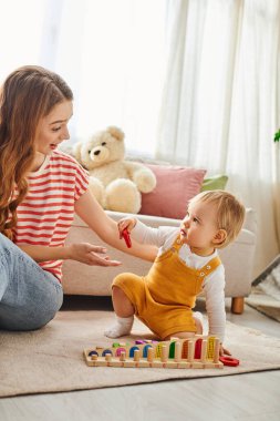 A young mother engages with her toddler daughter, playing together on the floor in a warm and loving moment at home. clipart