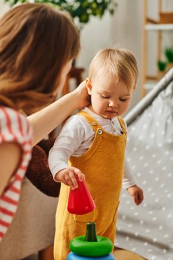 Genç bir anne, küçük kızına nazikçe dokunuyor. Birlikte çok güzel vakit geçiriyorlar..