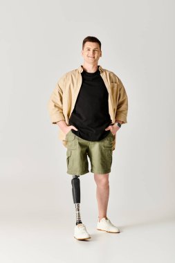 Handsome man with prosthetic leg standing confidently with hands on hips. clipart