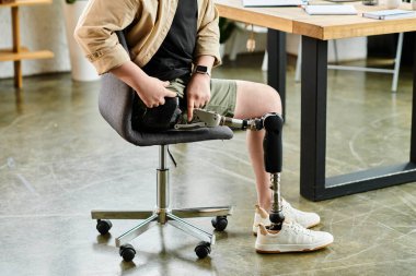 Ofisteki sandalyede oturan protez bacaklı yakışıklı bir işadamı..