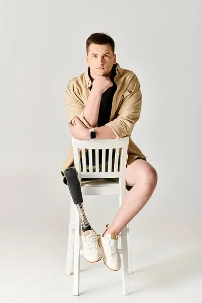 Handsome Man Prosthetic Leg Confidently Sits Top White Chair — Stock Photo, Image