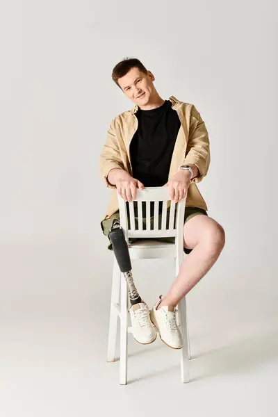 Protez Bacaklı Yakışıklı Bir Adam Gururla Beyaz Bir Sandalyede Oturuyor — Stok fotoğraf