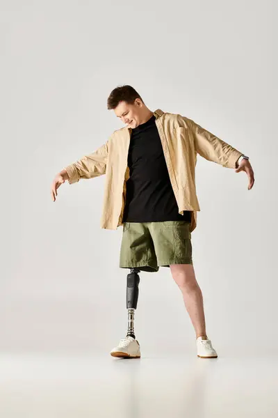 stock image A handsome man with a cast on his leg strikes a poised and active pose.