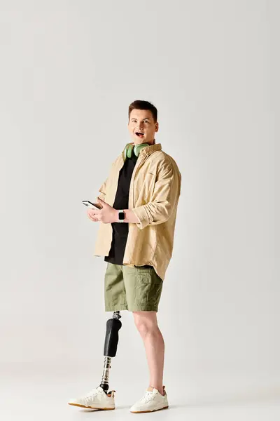 彼の携帯電話に従事している足にキャストを持つハンサムな男 — ストック写真