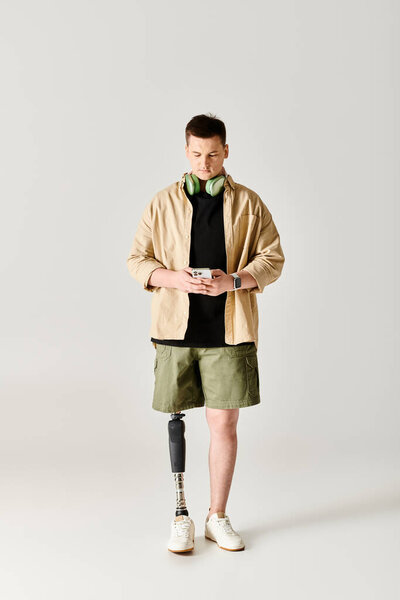 Красивый мужчина с гипсом на ноге уверенно балансирует на белом фоне.