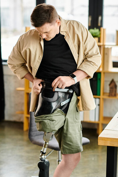 Бизнесмен с протезной ногой в черной рубашке и шортах цвета хаки.