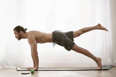 At home, a handsome man focuses on his core by doing a plank. clipart
