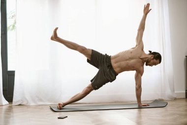 Evde yakışıklı bir adam, minderde yoga yapıyor..