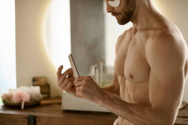 Shirtless man holds nail file, surrounded by grooming products. clipart