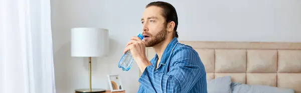 Een Knappe Man Een Blauwe Kledij Drinkwater — Stockfoto