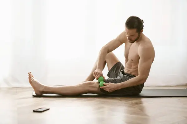 Bir Adam Elinde Masaj Topuyla Yerde Oturuyor Evde Yoga Yapıyor — Stok fotoğraf