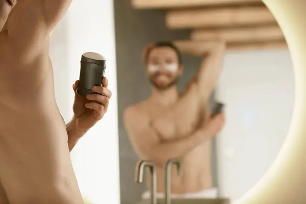 Man Using Deodorant Surrounded Skincare Products Grooming Mirror — Stock Photo, Image