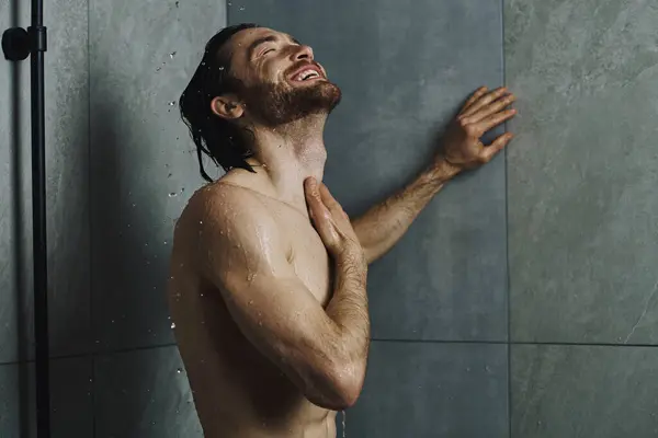 Mężczyzna Stoi Pod Prysznicem Podniesionymi Rękami Obejmujący Wodę — Zdjęcie stockowe